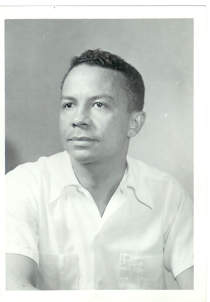 Black-and-white studio portrait of Dr. Gordon A. Rodgers Jr. in a short-sleeved white shirt, looking off to the side.